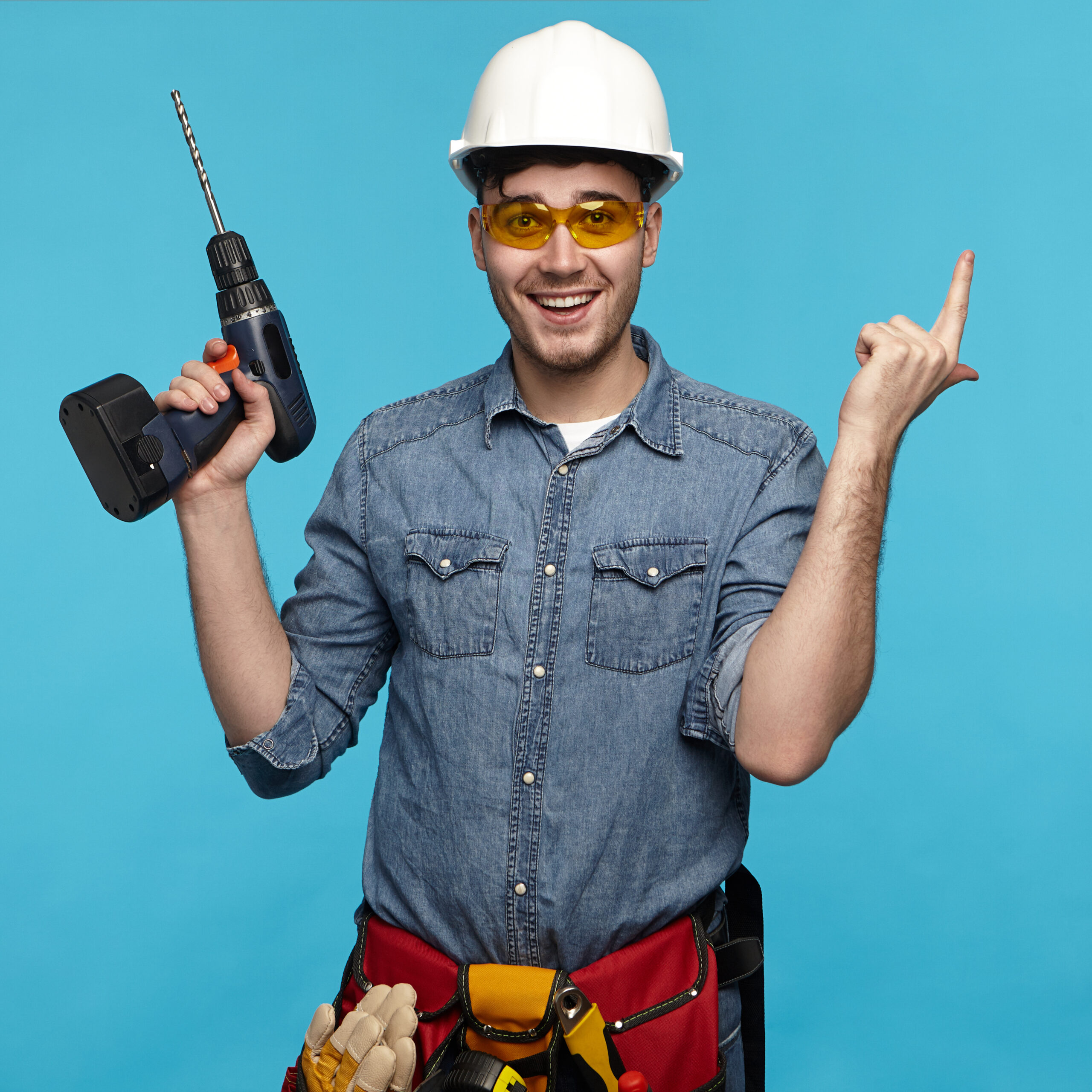 isolated studio shot of cheerful emotional young repairman weari